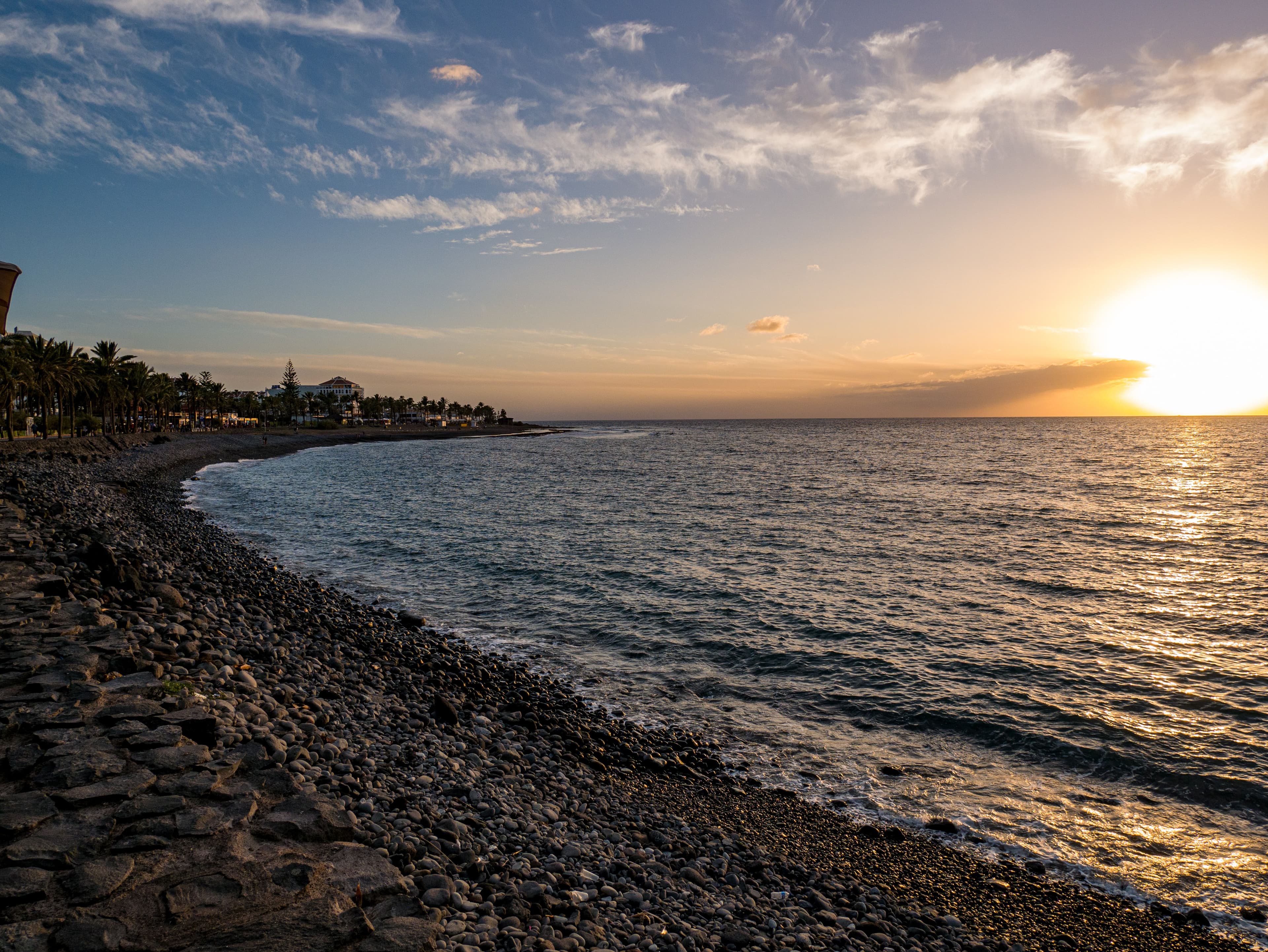 The sun going down over the sea from a rocky shore in the Canaries