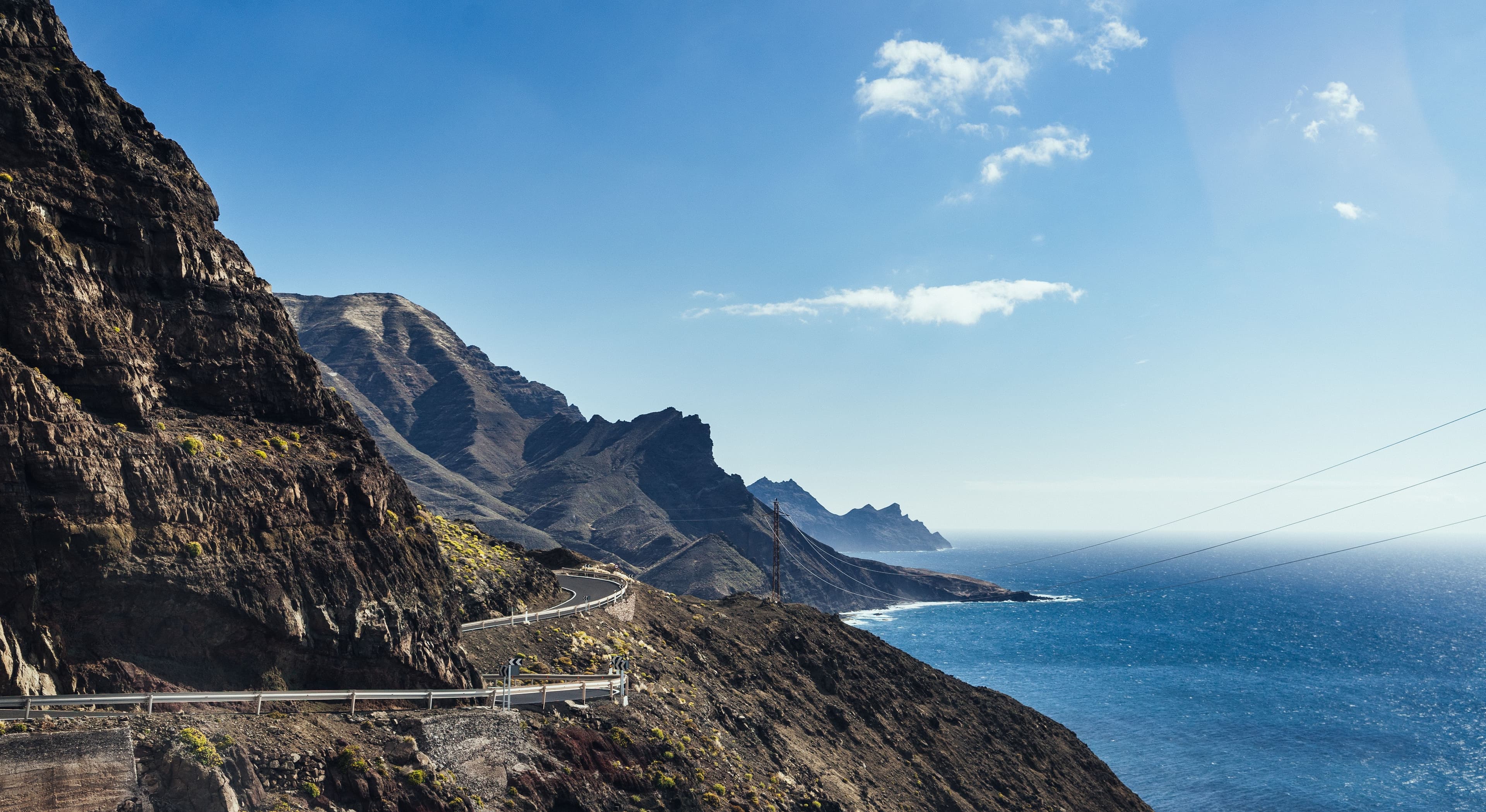 Une route côtière à flanc de falaise à Gran Canaria, dans la lumière dorée du soir
