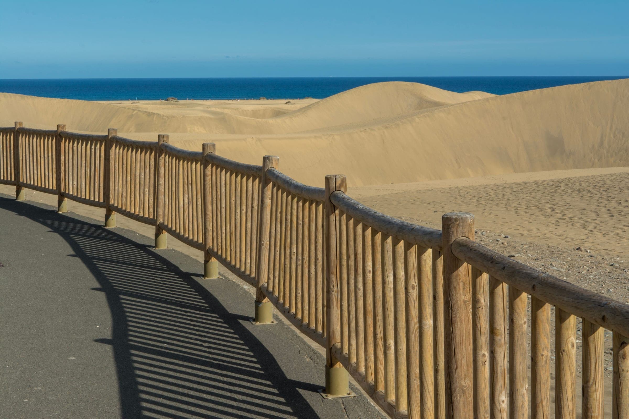 A boardwalk running out across the Maspalomas dunes toward the sea