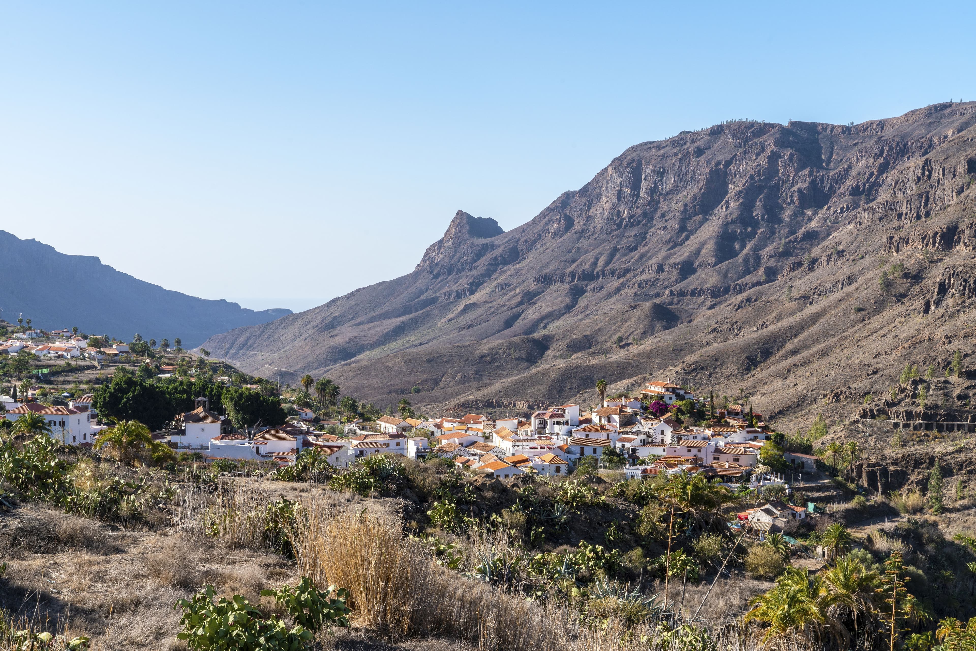 Houses spread along the foot of a mountain on Gran Canaria with roads threading between them