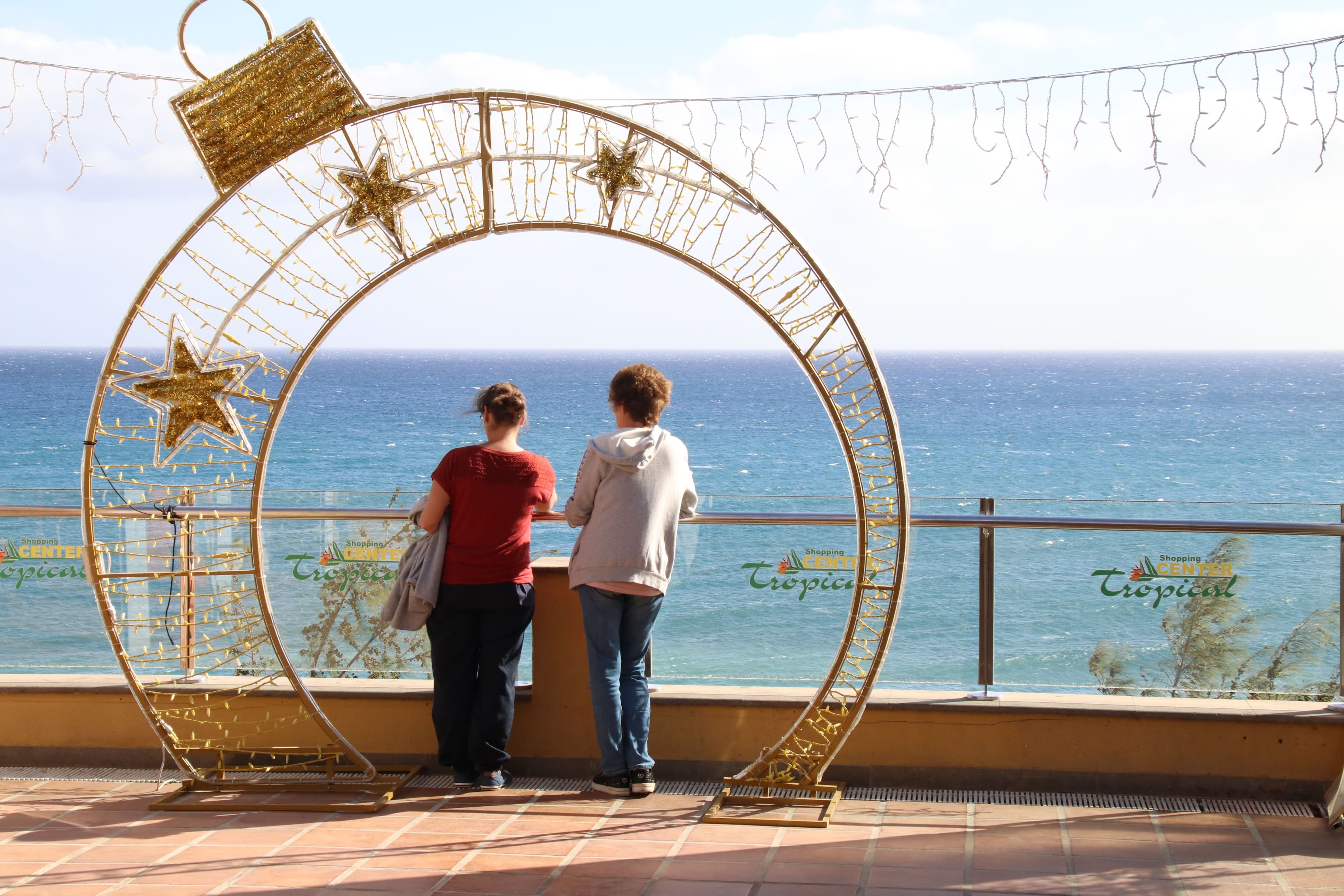 People looking out over the sea from the seafront at Playa del Ingles