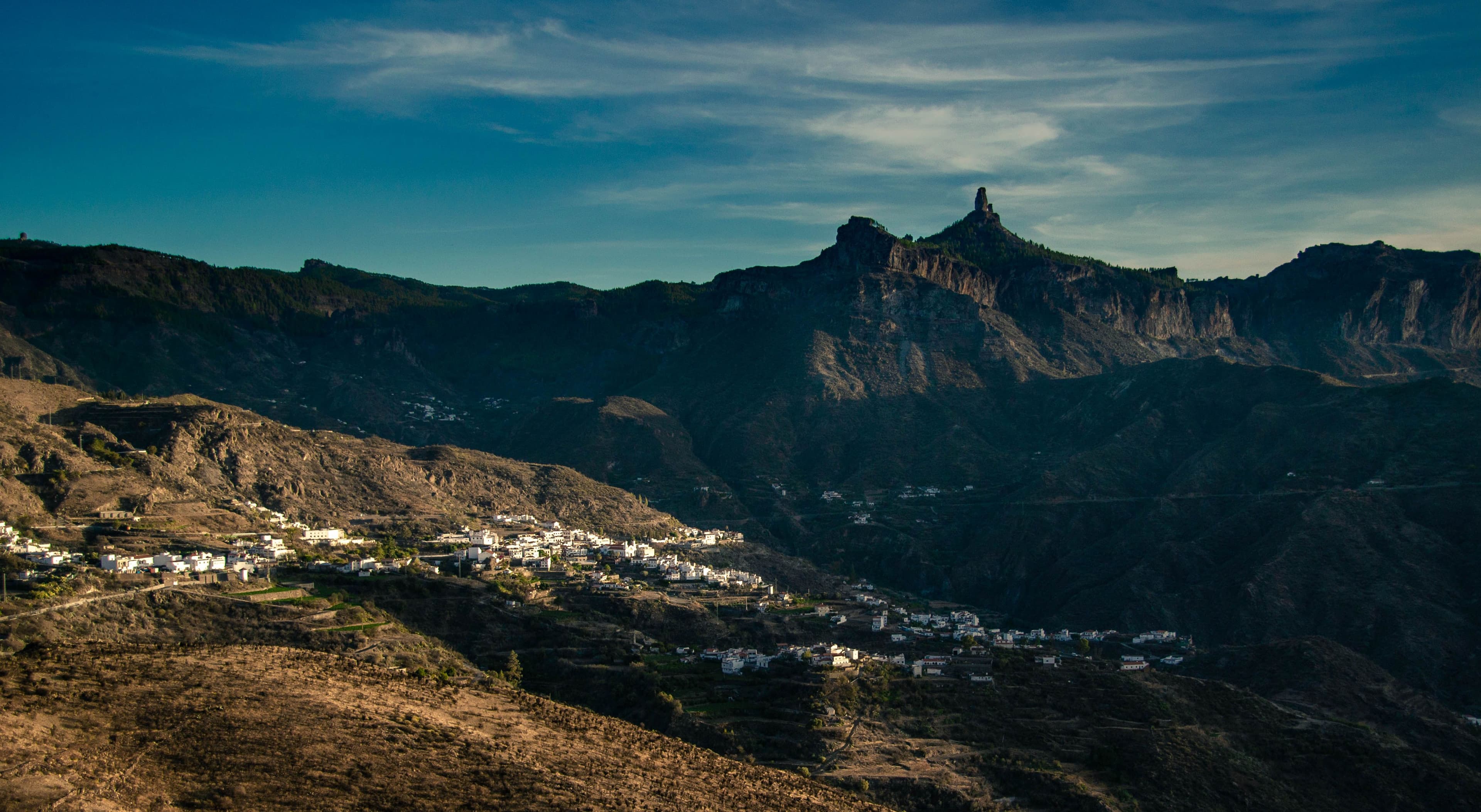 A whitewashed village below the peaks of Gran Canaria's interior in late afternoon light