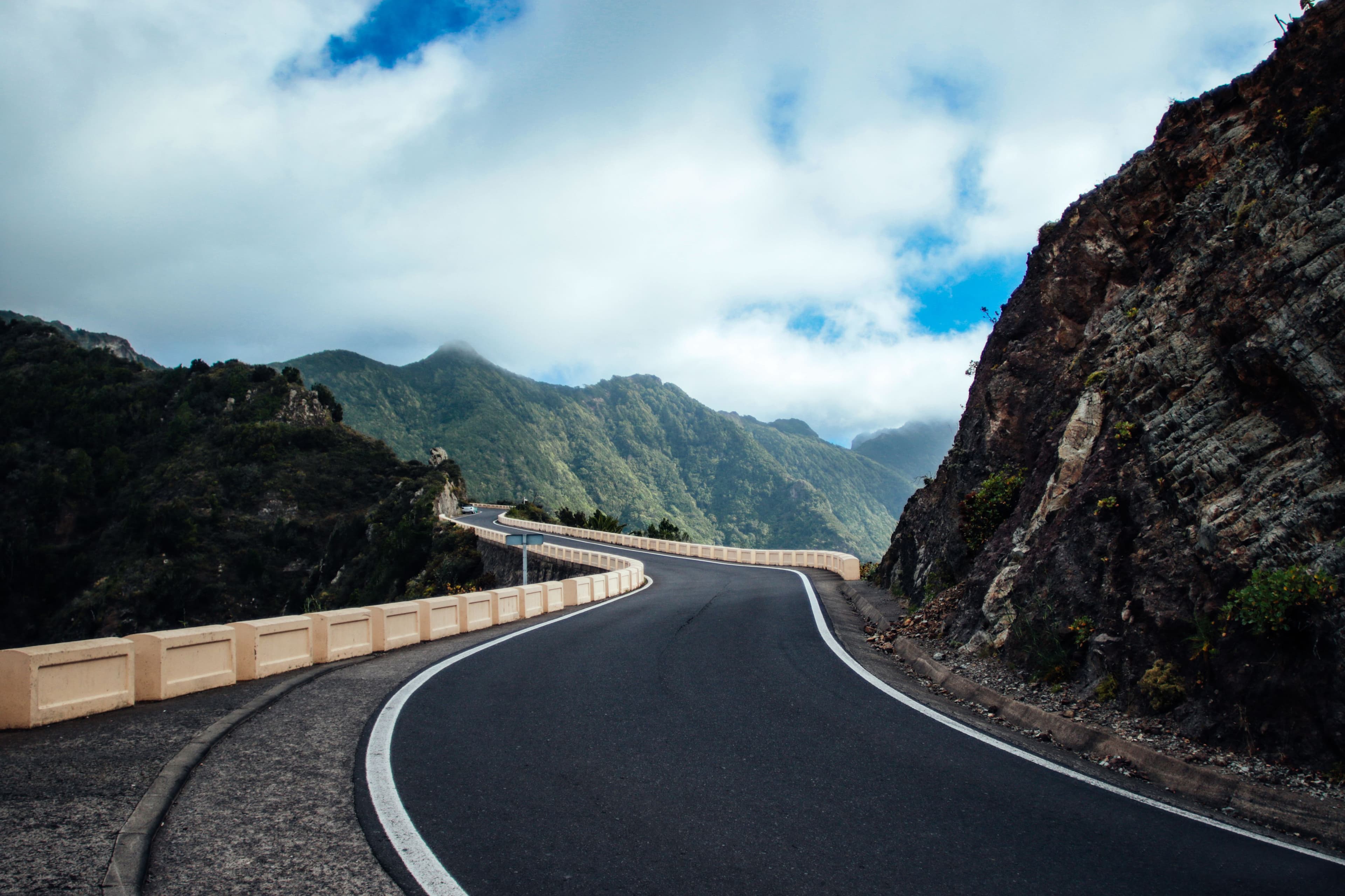 A road curving beneath steep cliffs on a Canary Islands mountainside
